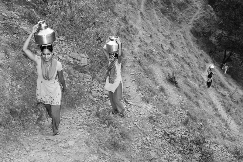 Girls fetching drinking water from faraway hill sources in district Tehri-Garhwal, Uttarakhand - depicting hardships caused by drying up of local drinking water sources due to the Tehri Dam project